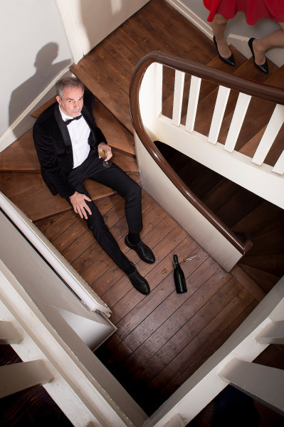 Portrait eines reichen Mannes auf Holztreppe, Filmisches licht, inszeniert.
